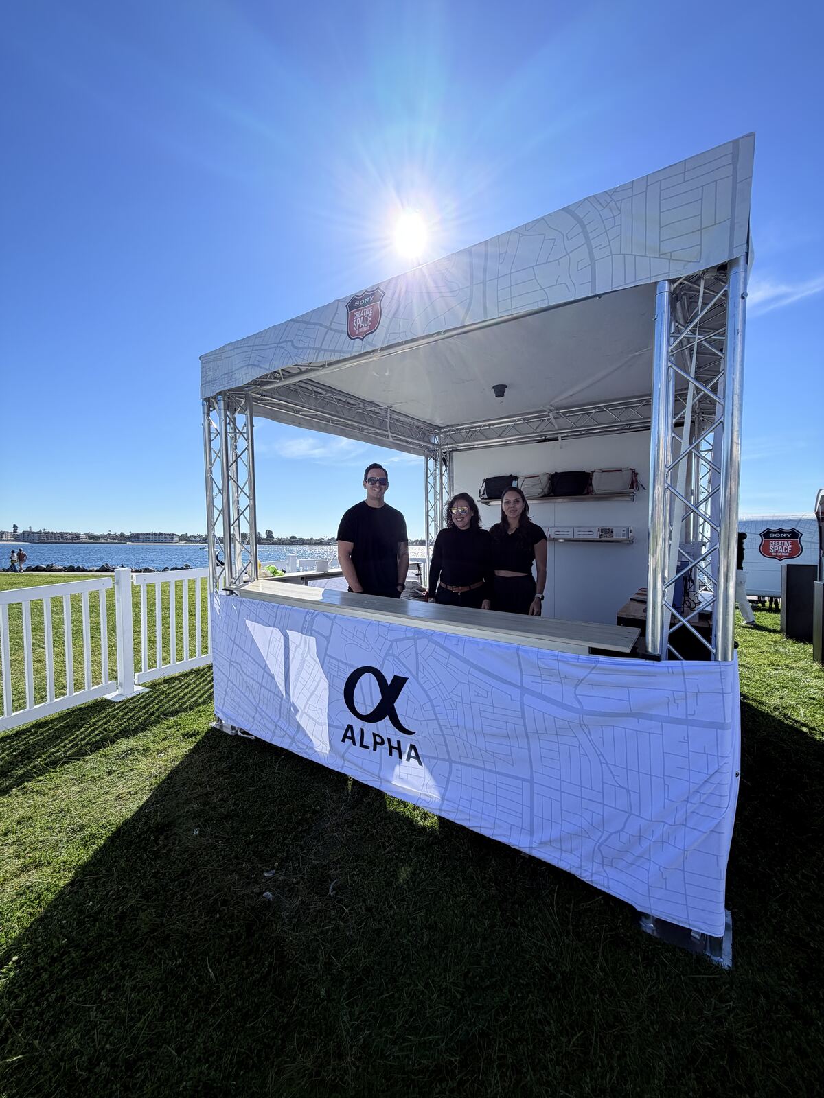 Event attendees wearing branded hats and apparel at a decorated merchandise booth