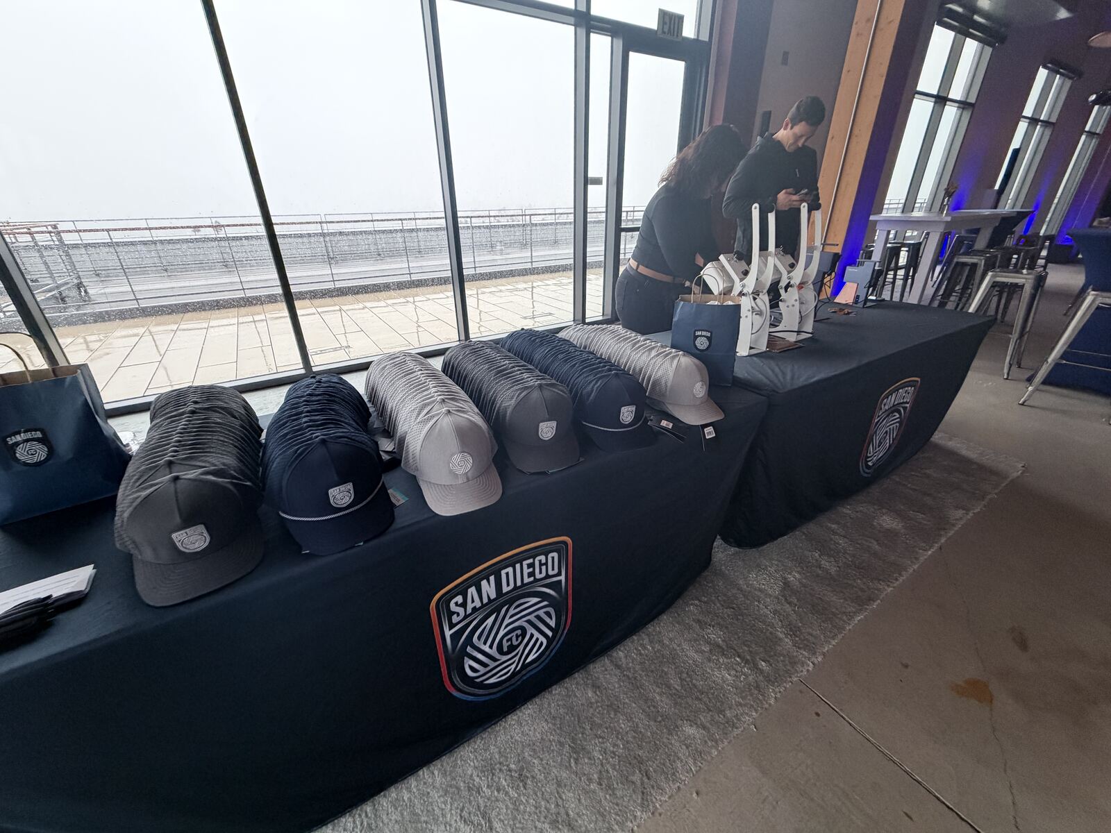 A branded hat display with multiple custom hats at a bachelorette event booth